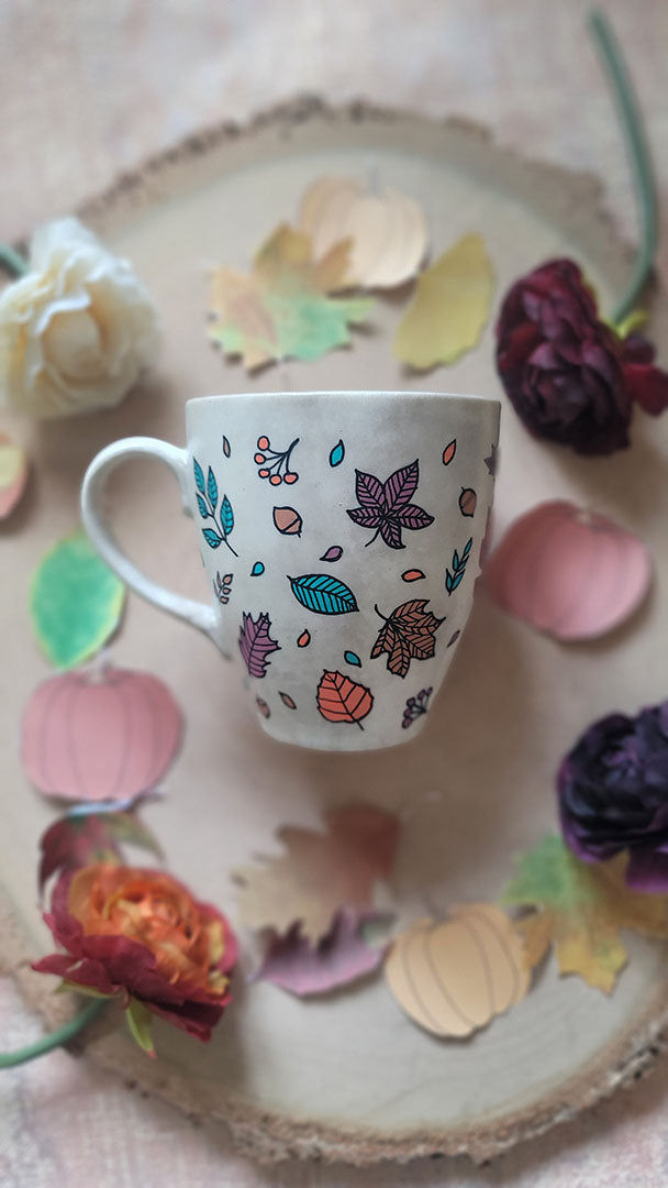 A Taupe Hand painted mug with autumn leaves scattered all over