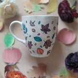 A Taupe Hand painted mug with autumn leaves scattered all over