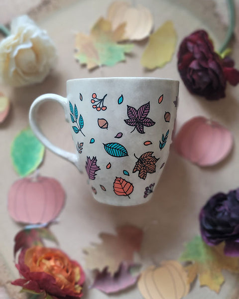 A Taupe Hand painted mug with autumn leaves scattered all over