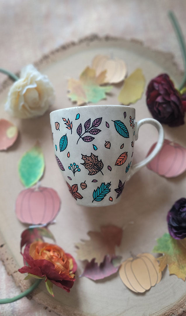 A Taupe Hand painted mug with autumn leaves scattered all over