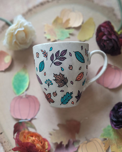 A Taupe Hand painted mug with autumn leaves scattered all over