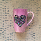 a Pastel Pink hand painted mug with a heart drawn in black filled with colorful patterns