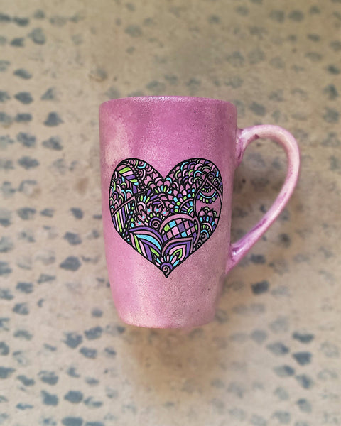 a Pastel Pink hand painted mug with a heart drawn in black filled with colorful patterns