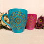 An indian blue hand painted mug with a mandala drawn in relief outliner