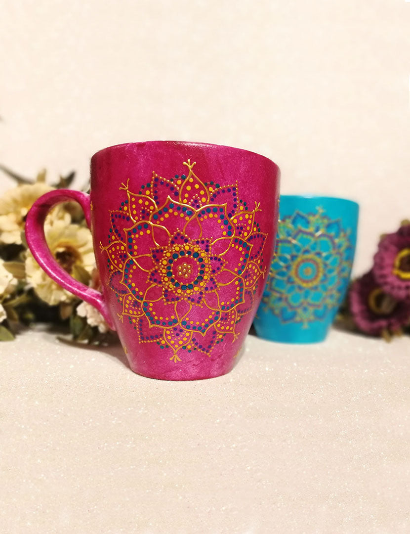 An indian pink hand painted mug with a mandala drawn in relief outliner