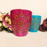 An indian pink hand painted mug with a mandala drawn in relief outliner