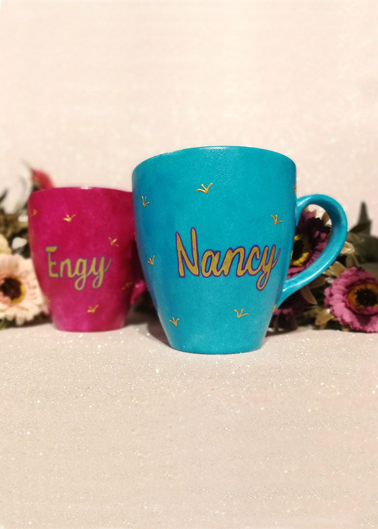 An indian blue hand painted mug with a the name nancy