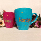 An indian blue hand painted mug with a the name nancy