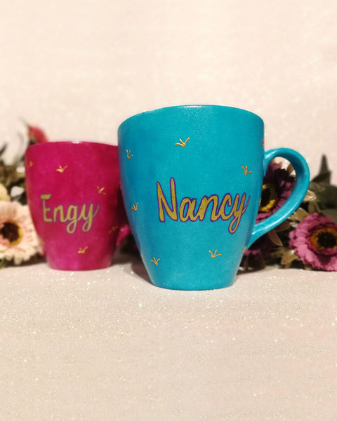 An indian blue hand painted mug with a the name nancy