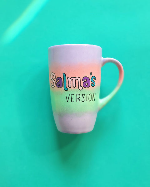 A gradient hand painted mug (lilac-peach-mint-lilac) with the sentence "Salma's Version"