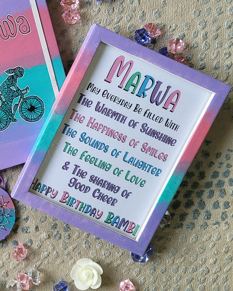 a gradient hand painted wooden frame (lilac-pink-mint-lilac) with the following words written inside "Marwa, may everyday be filled with the warmth of sunshine, the happiness of smiles, the sounds of laughter , the feeling of love and the sharing of good cheer. Happy birthday Bambie"