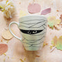 An Ivory hand painted mug with a Mummy drawn all over it