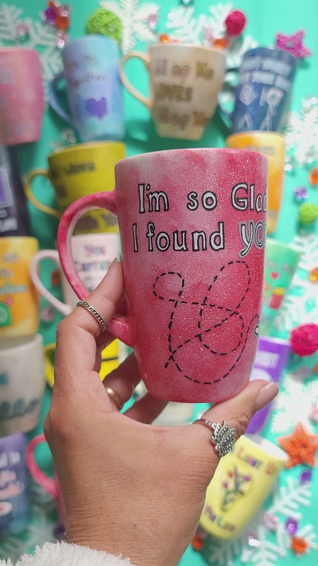 A hand-painted red galaxy mug with the words "I'm so glad I found you" and then a dotted line drawn like a path to reach a small heart in the bottom right corner. and on the other side the name "Nada"