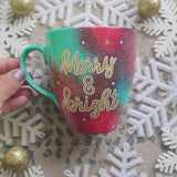 A Christmas galaxy colored hand painted mug with the words 