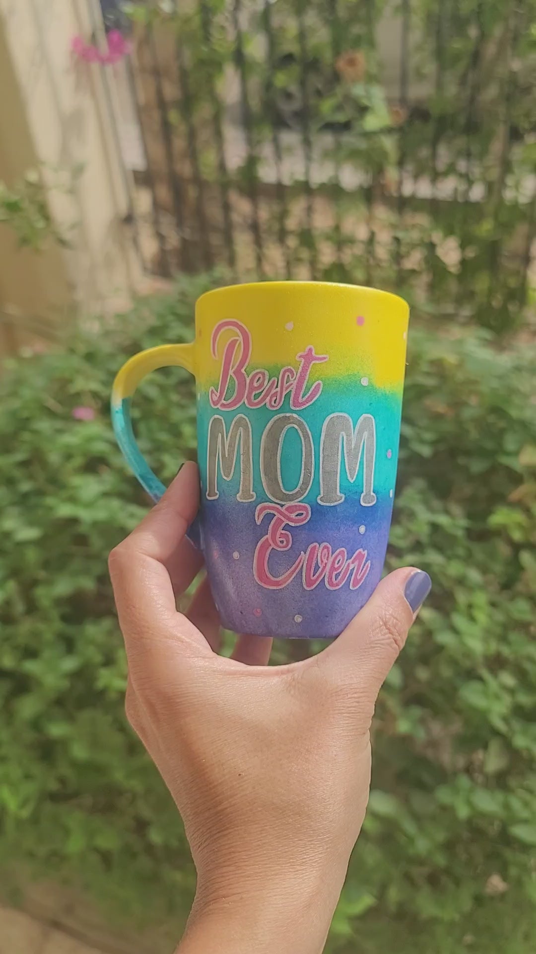 A Gradient colored hand painted mug with gradient colors of yellow turquoise and blue, with the words "Best Mom Ever" and the name "Yasmine" on the other side