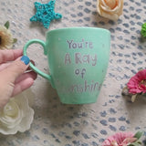 A Mint green handpainted mug with the words 