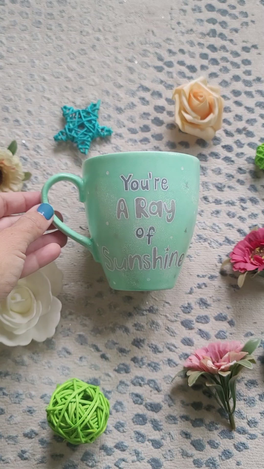 A Mint green handpainted mug with the words "you're a ray of sunshine" in silver and the other side has a snowflake