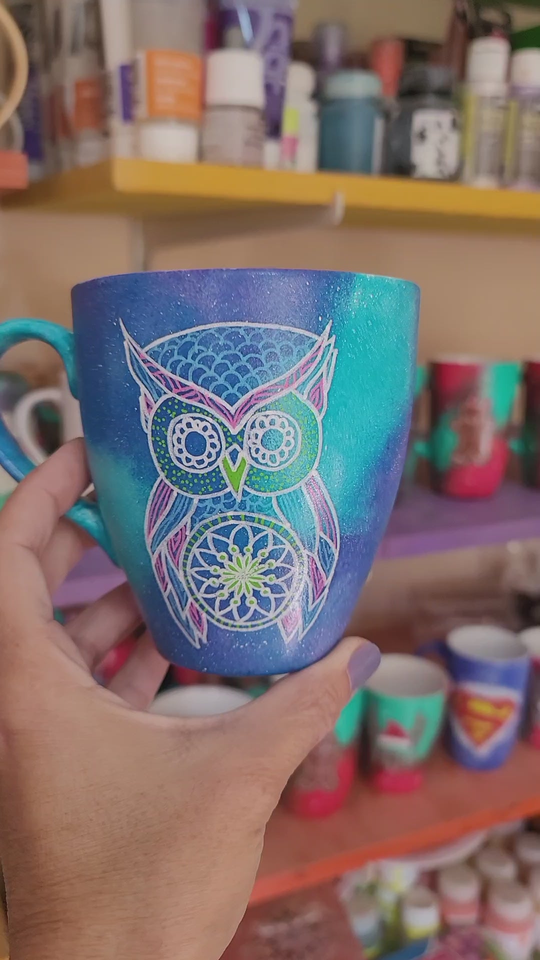 A Blue galaxy hand painted mug with an owl in zentangles drawn on it and the other side has the name "Hala"