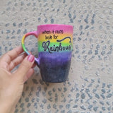 A Mug with the top half painted in rainbow and the bottom in dark galaxy, with the words on the rainbow written 