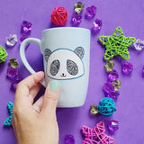 A baby blue hand painted mug with a panda face in zentangles on it and the name 