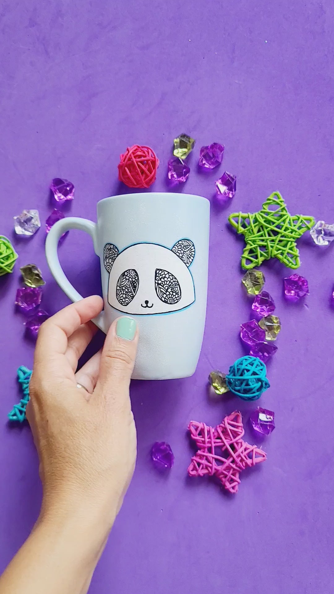 A baby blue hand painted mug with a panda face in zentangles on it and the name "Moni" on the other side