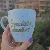 A baby blue hand painted mug with the sentence 