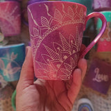 A hand-painted pink galaxy mug with a quarter mandala drawn in the corner and the word forever on the other side in silver and white outline