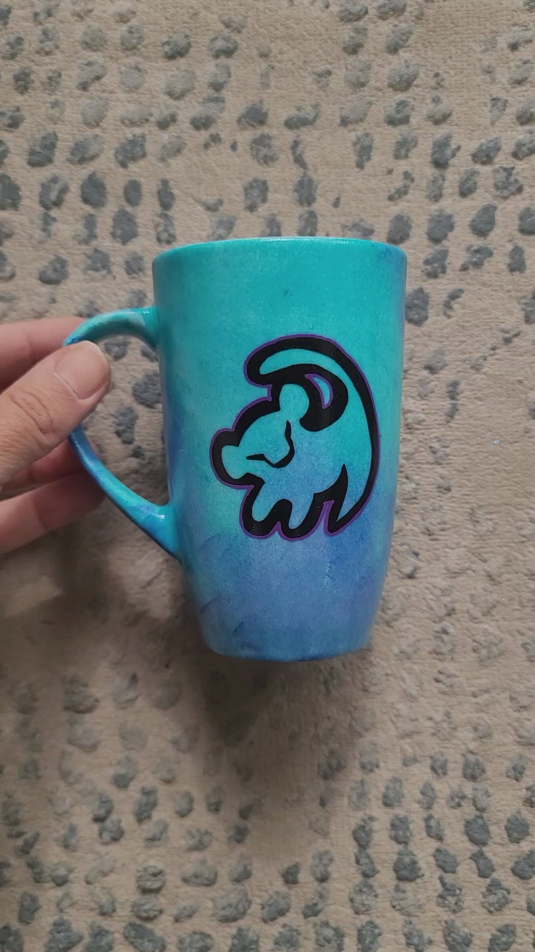 A Blue Hand painted mug with the an outline of baby lion in black and the other side has the sentence "remember who you are"