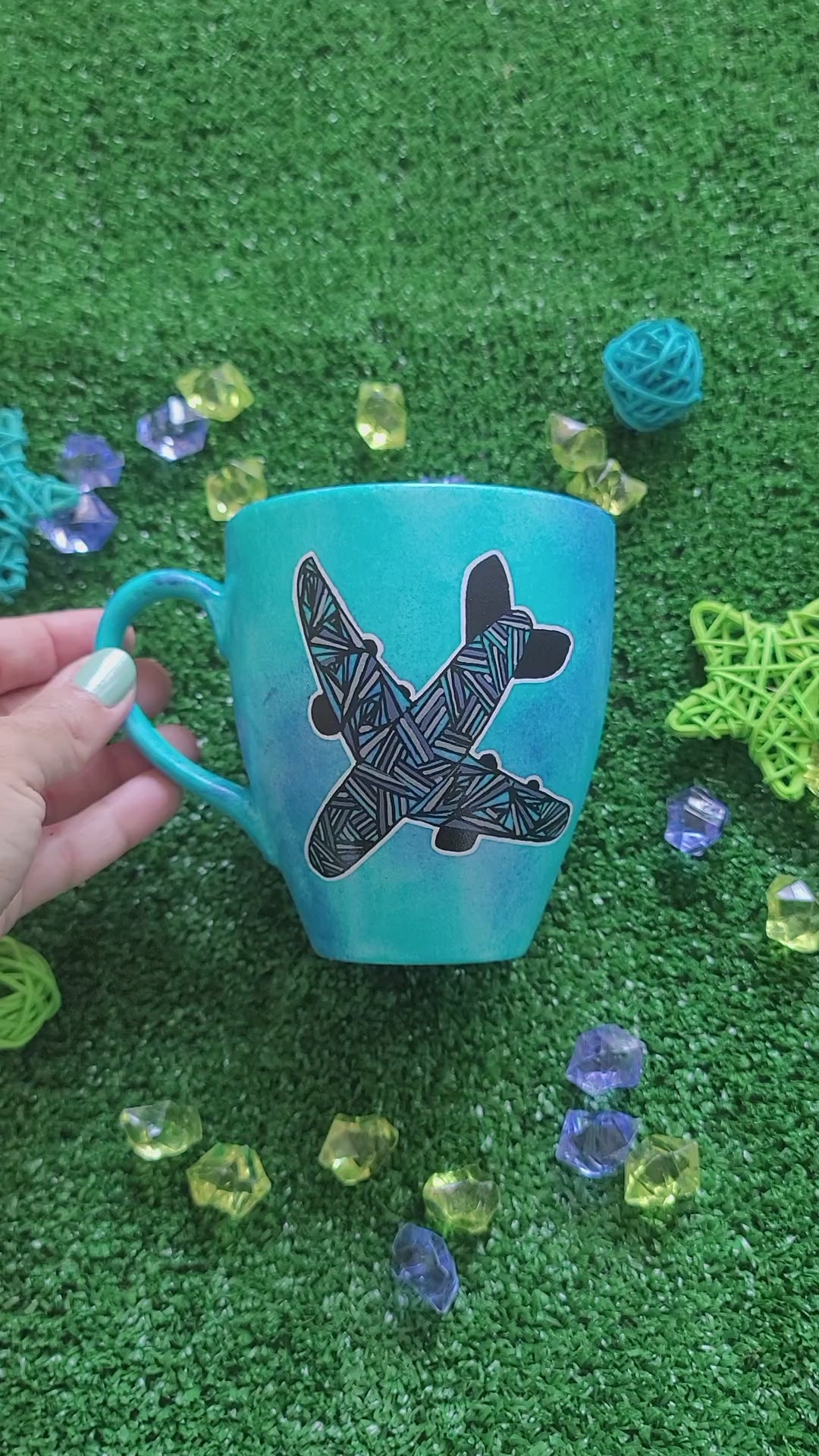 A Blue hand apinted mug with an airplane painted on it full of patterns in grey and the other side has the words "Piro the Hero"