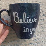 A Black galaxy hand painted mug with the words 