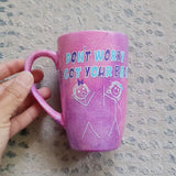 A hand painted pink galaxy mug with the words 