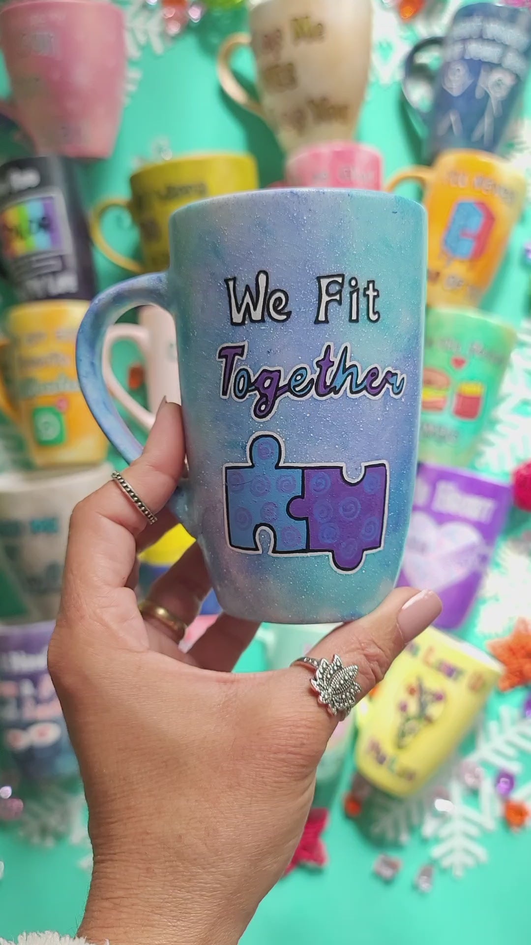 A hand-painted  light blue purple mug with the words "we fit together" and then below it a painting of two puzzle pieces perfectly fitting together. Then on the other side the name "Nancy"