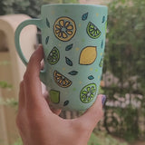 A Mint Green mug with lemons scattered all over