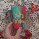 A Christmas galaxy colored hand painted mug with the words 