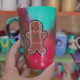 a christmas colored hand painted mug with a gingerbread cookie boy painted on it and the other side has the name Zoza