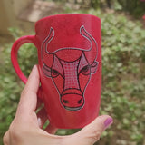 A video Showing a  hand-painted red black mug with Taurus sign on one side and the name 