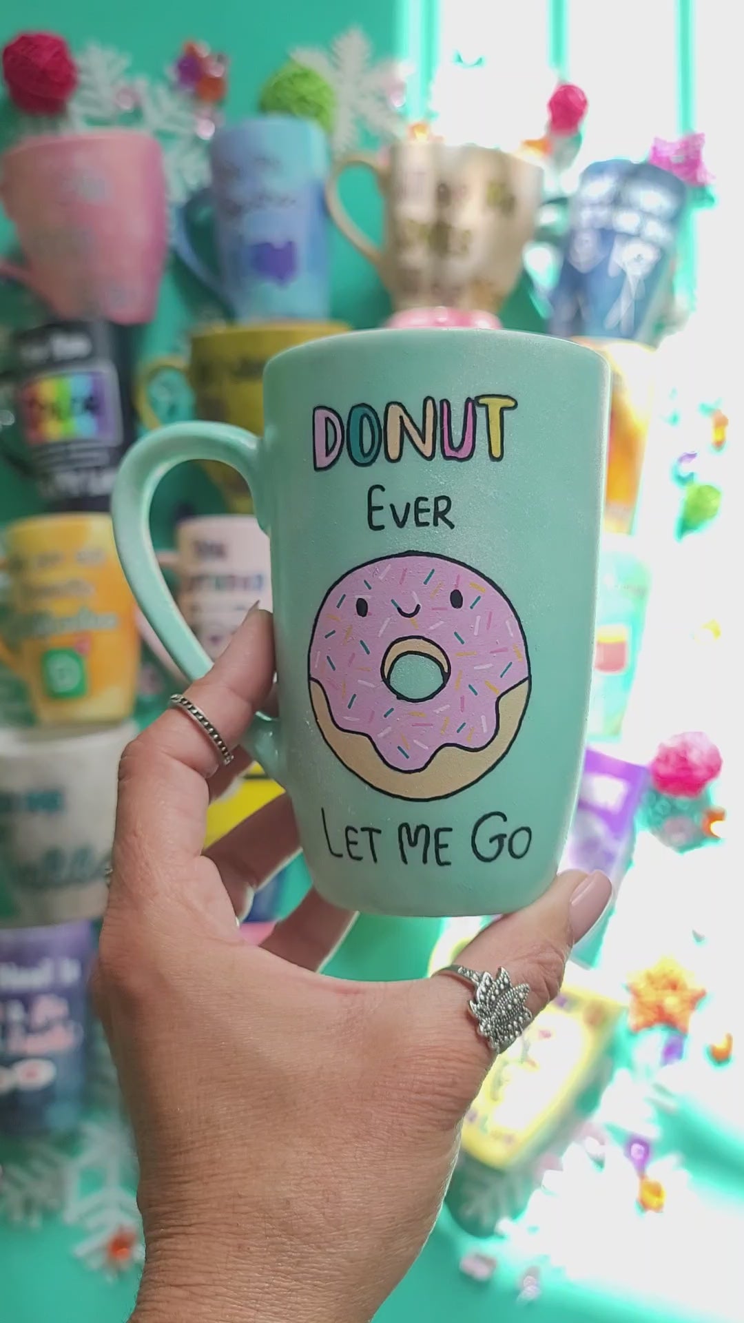 A Pastel green Hand-painted mug with the words "DONUT ever" and then below it a donut painted with pink frosting and sprinkles and a small smiley face. then below it the words "let me go". Then on the other side the name "Maria"