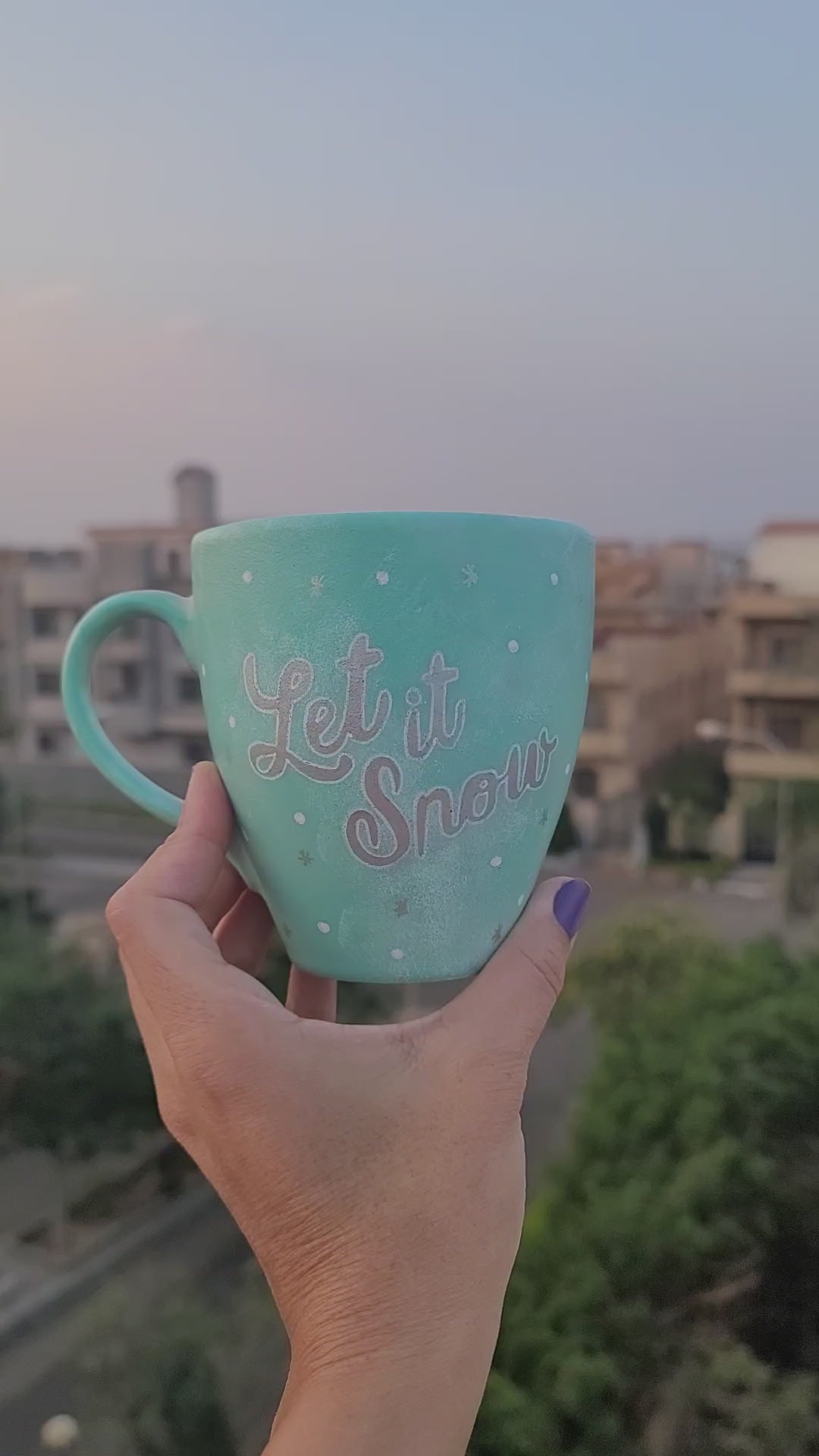 A Mint hand painted mug with the words "let it snow" in silver and  a snowflake on the other side