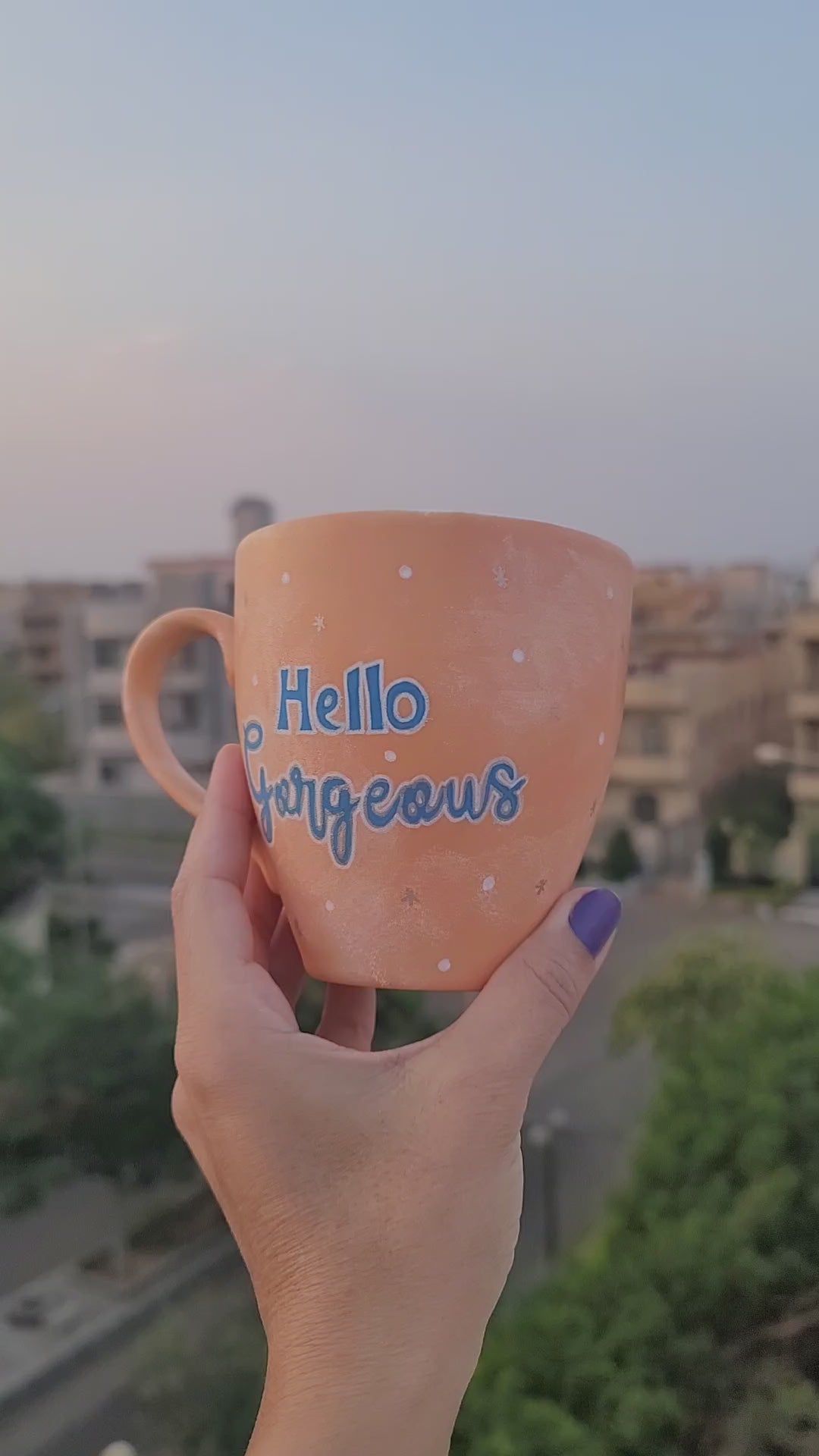 A Baby Orange Hand-painted mug with the words "hello gorgeous" and on the other side 2 closed eyes with long lashes