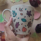 A Taupe Hand painted mug with autumn leaves scattered all over