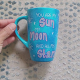 A Blue Galaxy Hand painted mug with the sentence 'you are my Sun, My Moon and all my stars