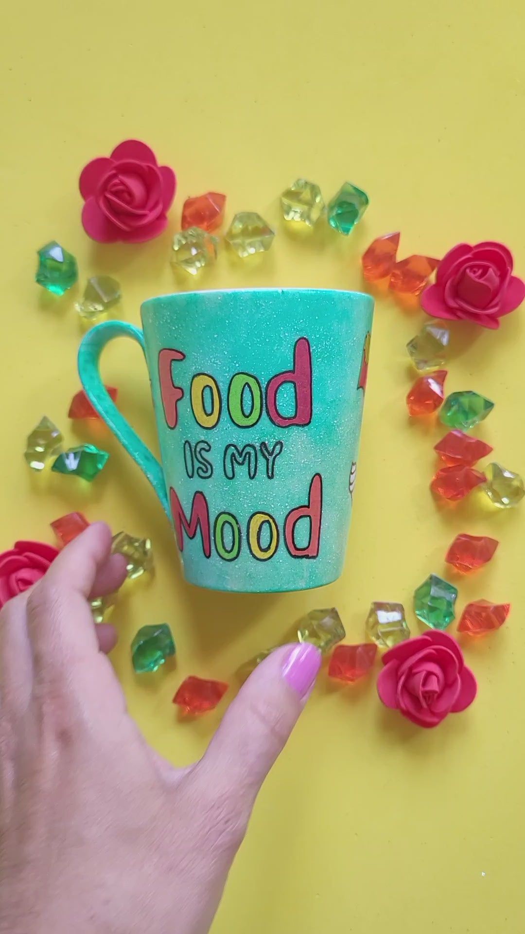 A green Galaxy hand painted mug with the words "food is my mood" and fast food items scattered all over, and the other side has the name "Ereny"