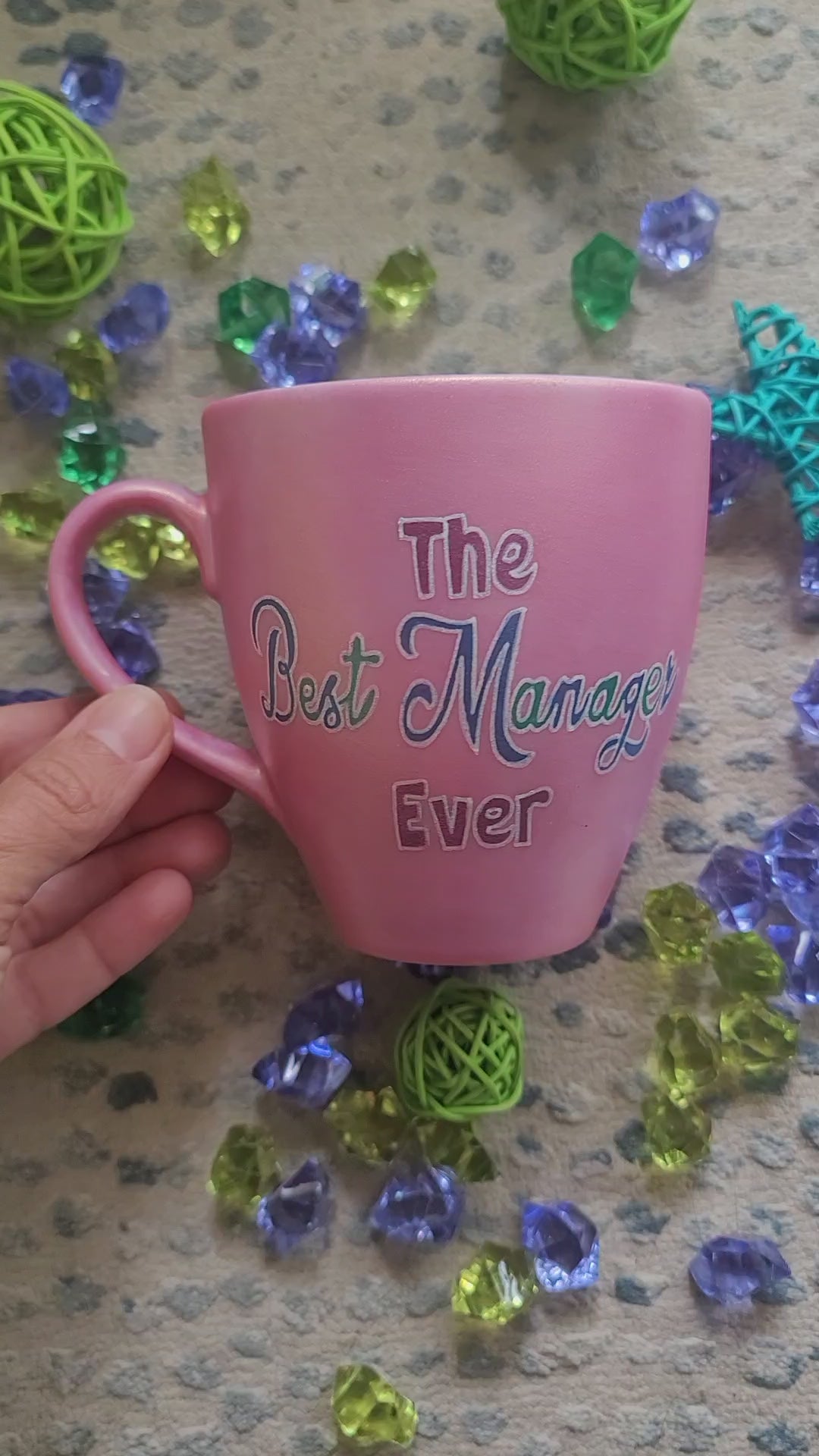 A Shimmery pink hand painted mug with the words "The Best Manager Ever" and the other side has the name "Viola Nader"