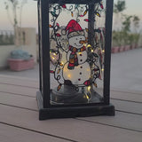 A Black Vintage Lantern with 4 hand painted glass sides.  the first with a snowman, the second with the name 