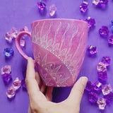 A Pink galaxy Hand painted mug with a 1/4 mandala drawn starting at the corner and the other side has the words 