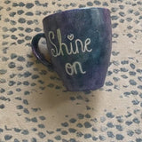 A Black galaxy hand painted mug with the words 