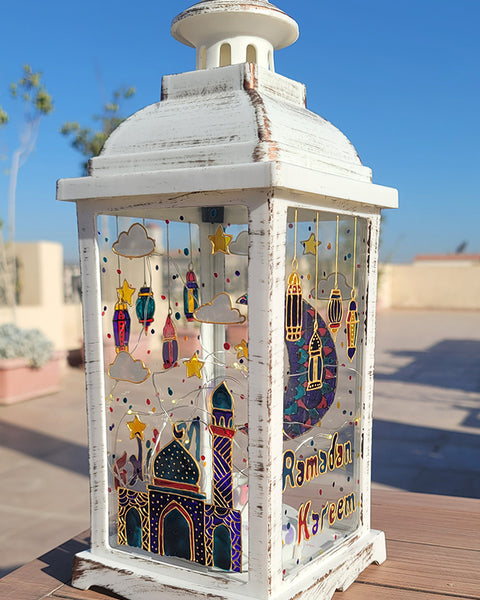 A White vintage lantern with a ramadan design dawn on it with gold relief and the name malika