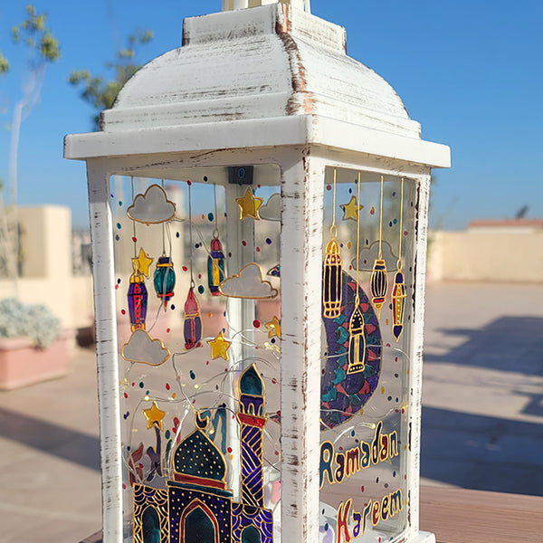 A White vintage lantern with a ramadan design dawn on it with gold relief and the name malika