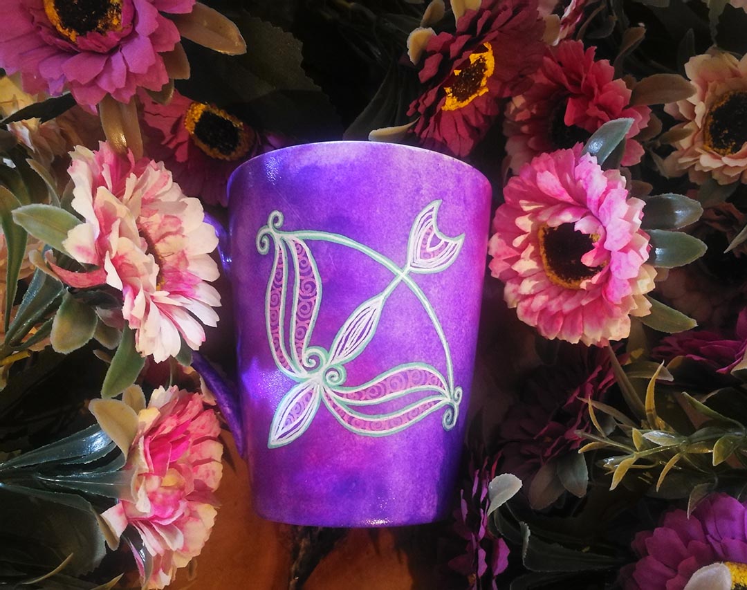 a hand-painted purple mug with a Sagittarius sign