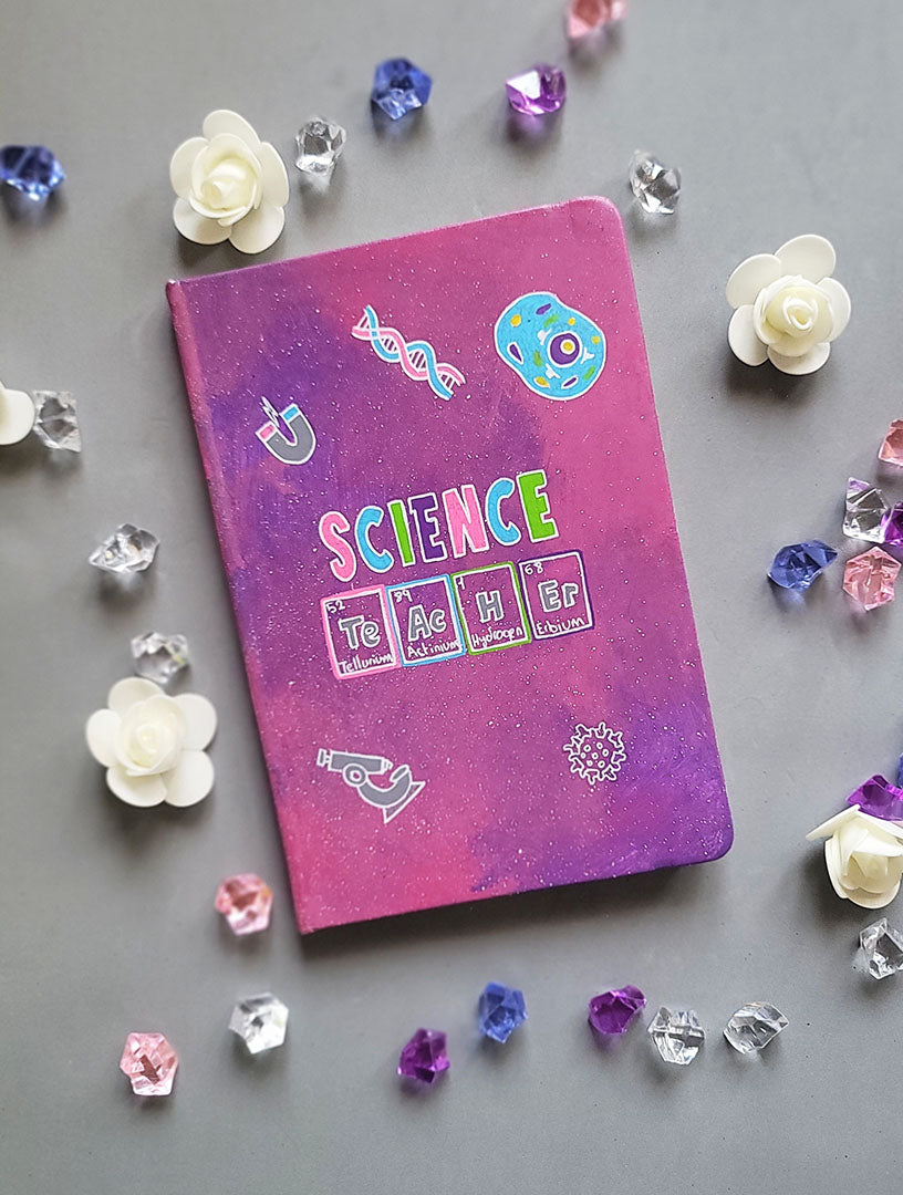 A Pink Galaxy Hand painted notebook with the word Science on it and under it the word teacher written in the form of periodic table elements. with science items scattered all over